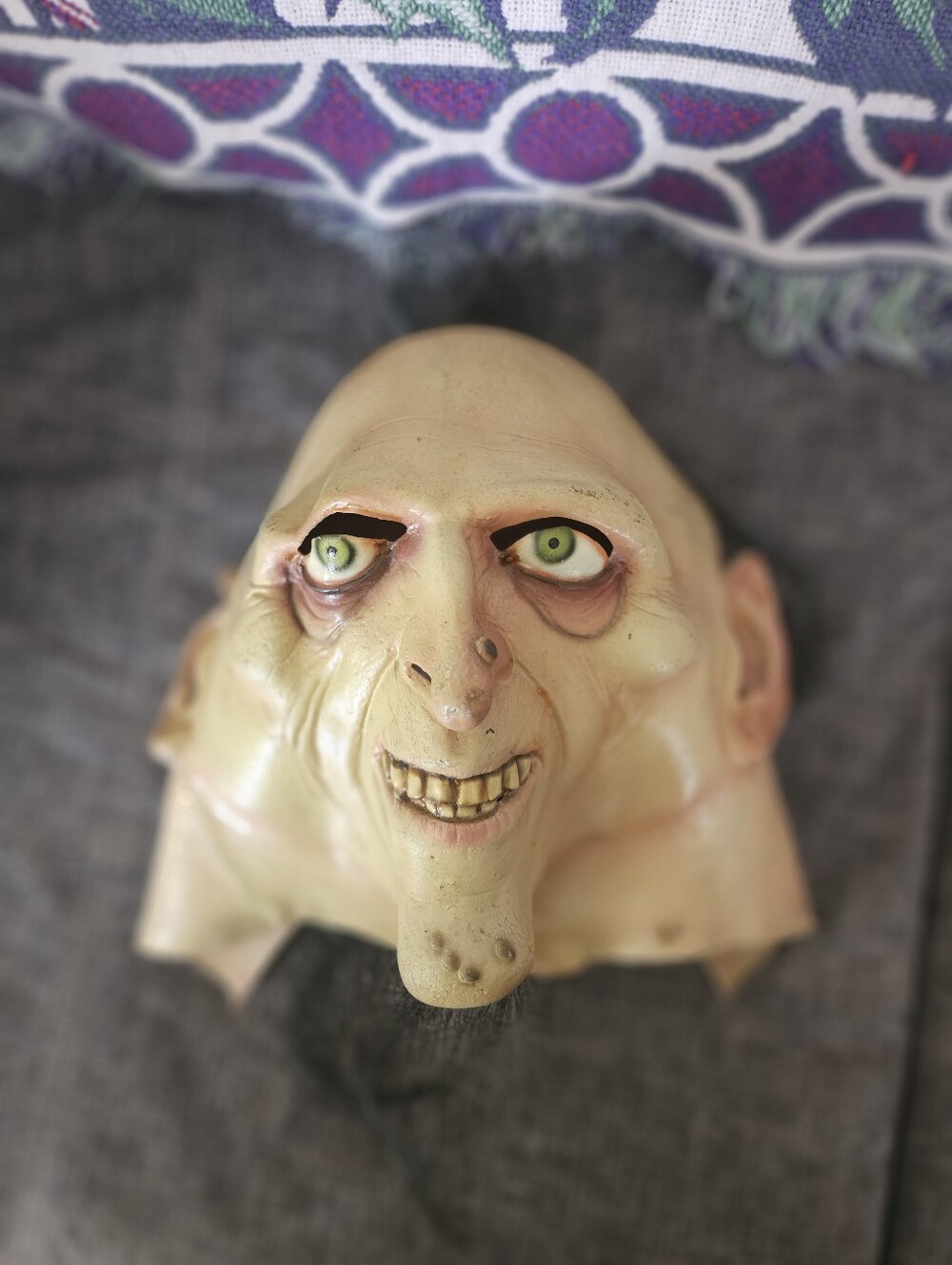 Latex Halloween mask depicting a grotesque elderly character or goblin